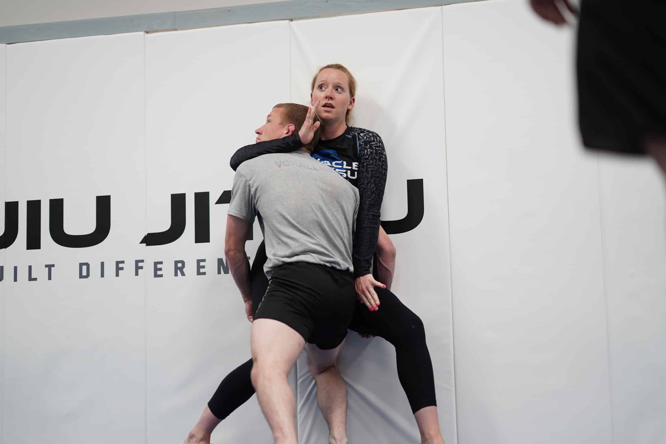 pinnacle jiu jitsu students grappling against wall